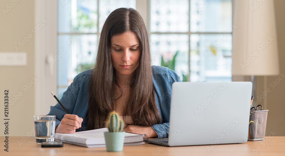 Young student woman studying at home with a confident expression on smart face thinking serious Young student woman studying at home with a confident expression on smart face thinking serious