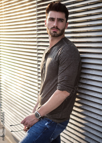 Attractive young bearded man portrait in urban environment, in a street, looking to a side © starsstudio