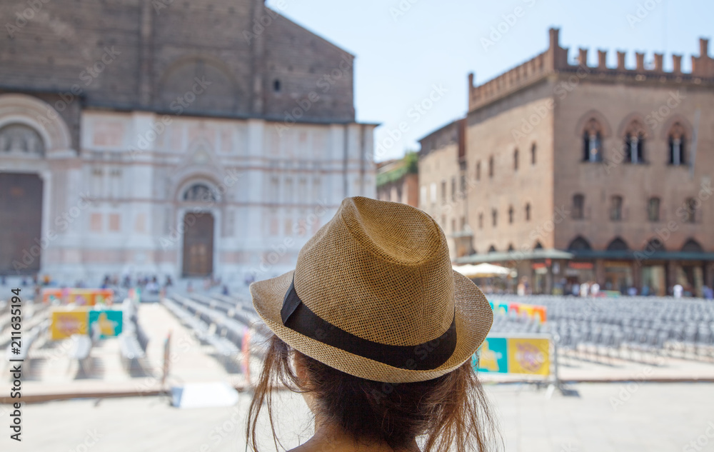 Traveler girl with hat looking the main square of Bologna (Piazza Maggiore)- the city of culture - Italy