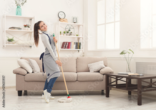 Happy woman cleaning home with mop and having fun