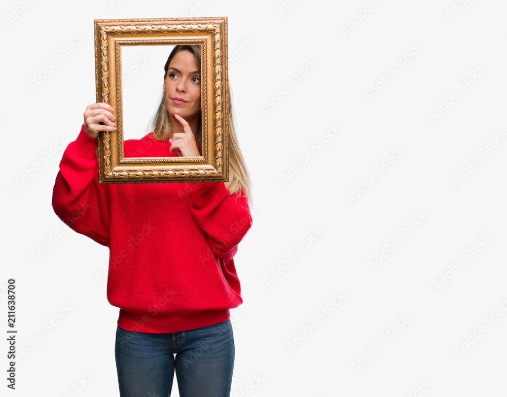 Beautiful young woman holding vintage frame serious face thinking about question, very confused idea