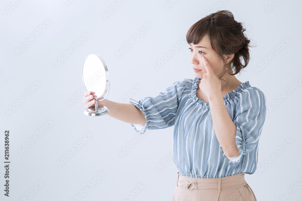 鏡で目を見る女性 鏡で目を見る女性