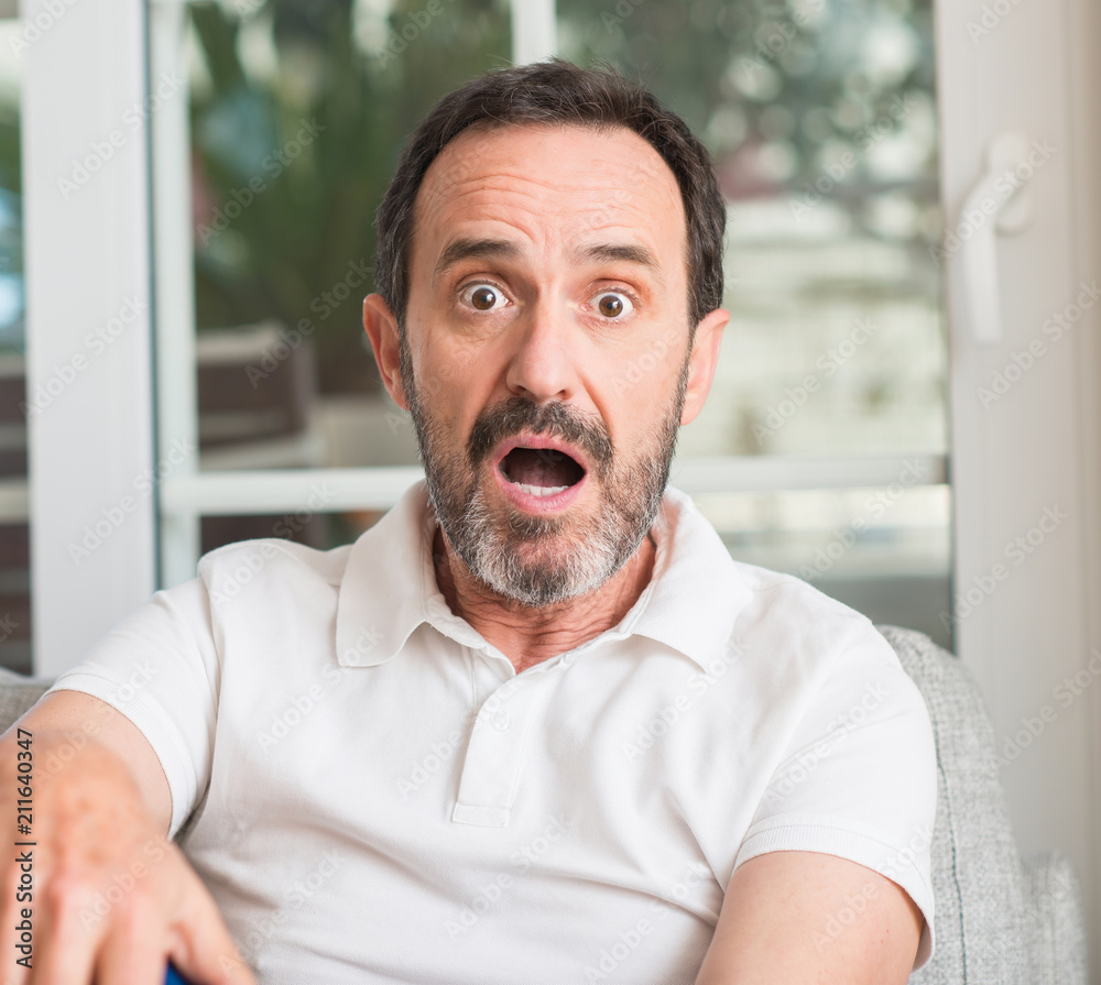 Handsome middle age man scared in shock with a surprise face, afraid and excited with fear expression Handsome middle age man scared in shock with a surprise face, afraid and excited with fear expression