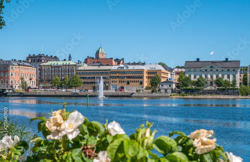 The city of Harnosand in north part of Sweden. Flowers and lake in foreground. Center in background. Summer daytime.