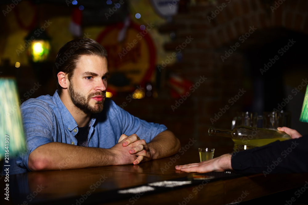 Man with beard sits at bar counter on pub background. Man with beard sits at bar counter on pub background.