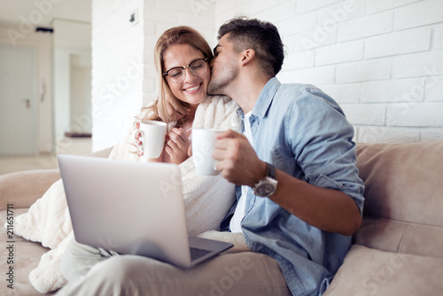 Canvas Print Couple watching a movie on laptop in their living room