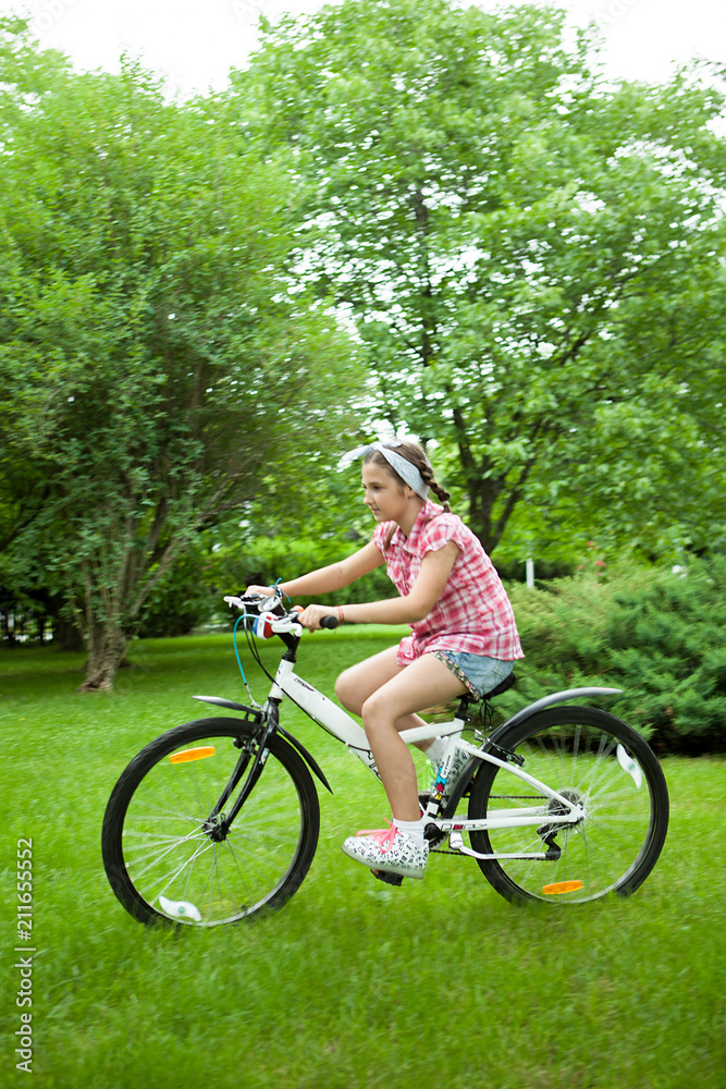 Girl feeling good while riding her bicycle in the park 
