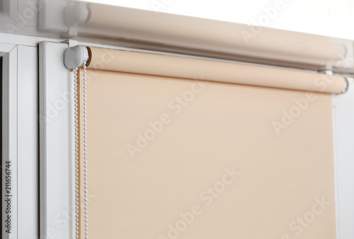 Fotografie Beige blackout roller blind on the white plastic window