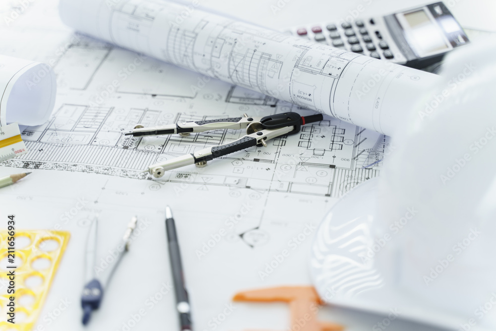 Construction plan with drawing tools in the blueprints and white hat and a calculator. Construction plan with drawing tools in the blueprints and white hat and a calculator.