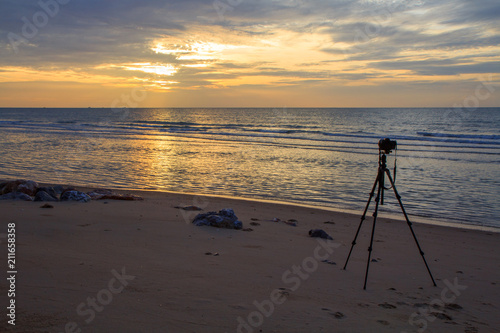 Tripod of Photographer for take the photo of the sea in sunrise time 