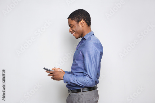 Profile of young african man with mobile phone against white background