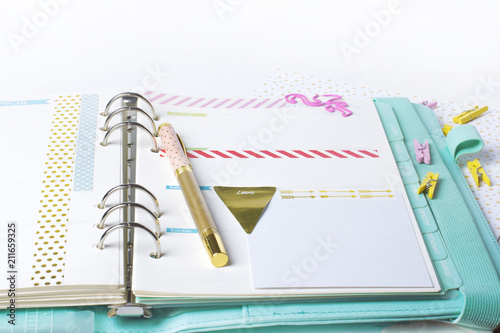 Feminine stationery: colorful paper binder clips palm and flamingo shape on white table background with washi tape. Flat lay