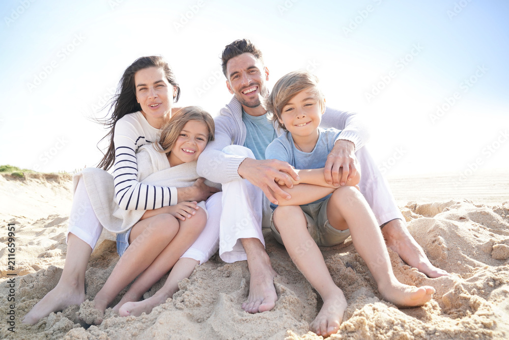 Family sitting on the beach in late afternoon Family sitting on the beach in late afternoon