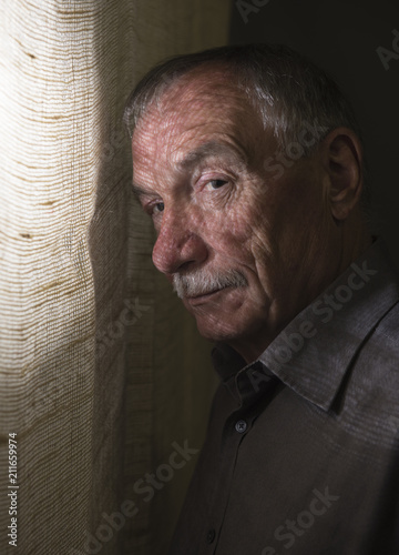 Vertical image of a mature man with shadow pattern on his face 