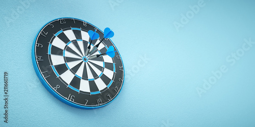 Arrows on target dart on blue background photo