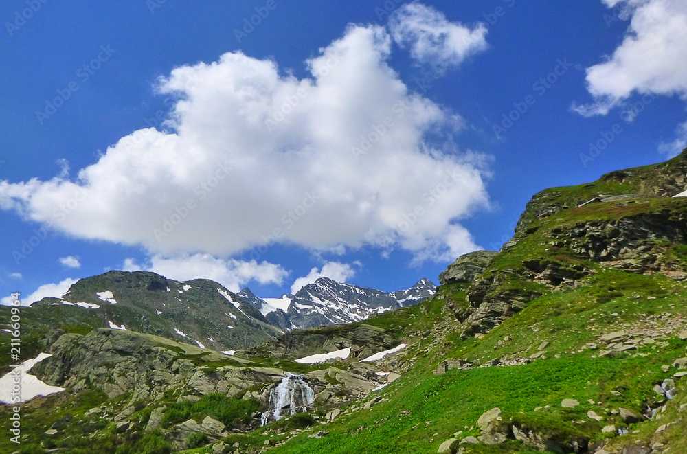 panorama of mountains with meadows and waterfalls