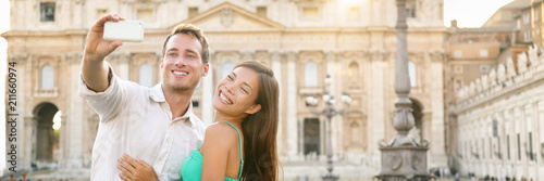 Photography Rome luxury vacation travel honeymoon couple taking selfie picture with mobile phone on vacation in front of Vatican, banner panorama horizontal crop