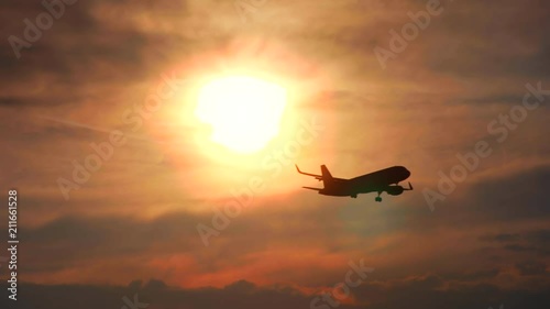 The plane flies against the background of the sunset