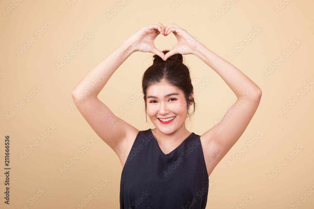 Young Asian woman gesturing heart hand sign. Young Asian woman gesturing heart hand sign.