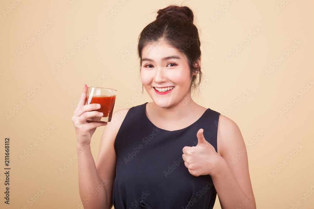 Young Asian woman show OK with tomato juice. Young Asian woman show OK with tomato juice.