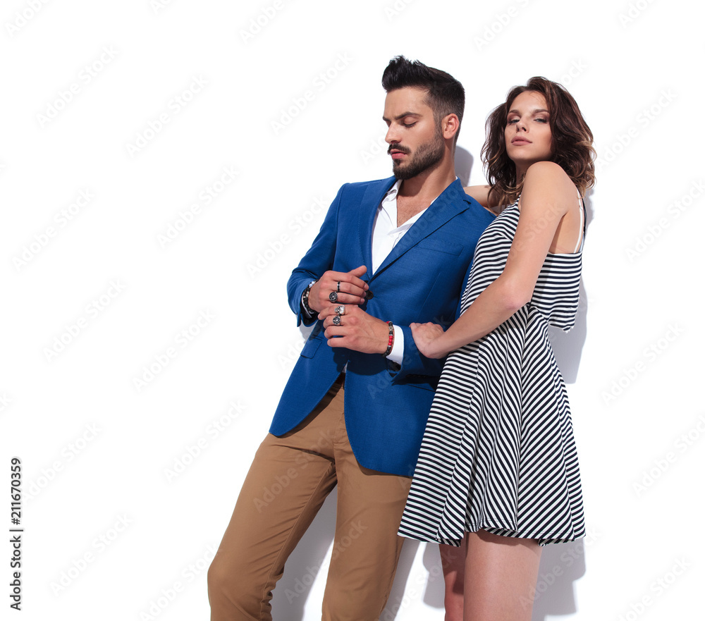 Naklejka premium sexy woman holds his casual man by his forearm