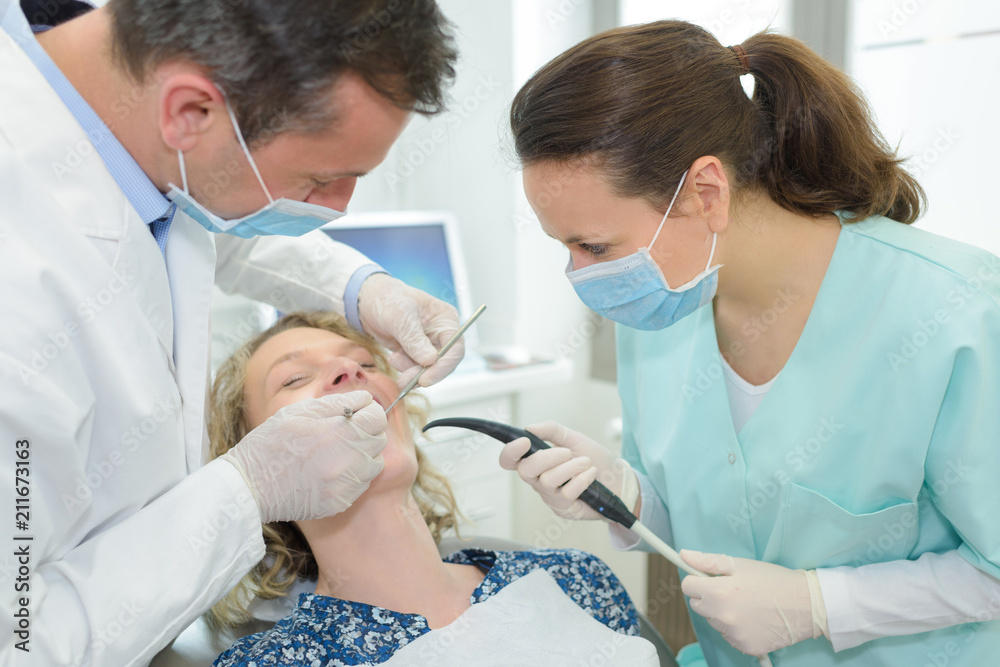 female dentist shaking hands with woman in the dentists chair female dentist shaking hands with woman in the dentists chair