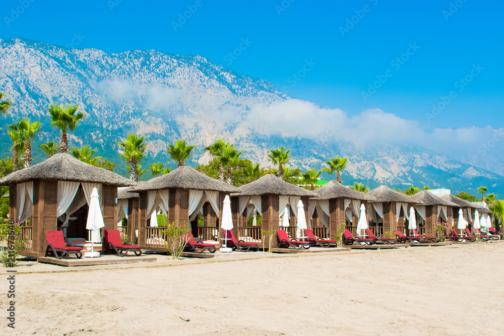 Wooden beach pavilions on the shore of a sandy beach