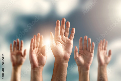 Many human hands, palms raised up against the sky. The concept of voting, free choice, own opinion, freedom of speech.