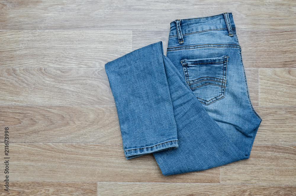 jeans on the background, blue jeans lie on a wooden background, jeans on the background, blue jeans lie on a wooden background,