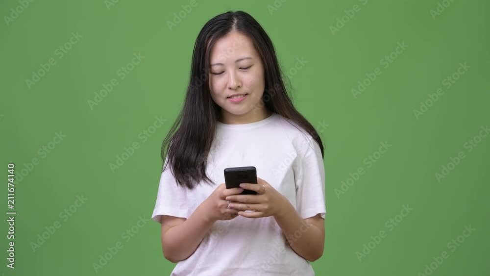 Young Asian woman thinking while using phone Young Asian woman thinking while using phone