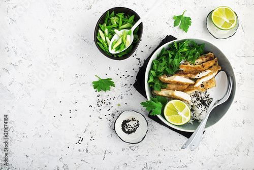 Rice chicken breast bowl with spring green onions and herbs