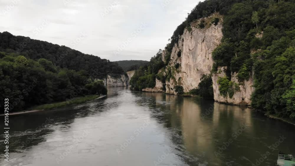 A slow downward panning drone shot from a distance of a beautiful bend in the Danube River near Kelheim in Germany. A slow downward panning drone shot from a distance of a beautiful bend in the Danube River near Kelheim in Germany.