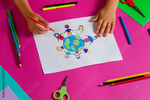 Kids draws with pencils and markers peace in the world. Child drawing the friendship of the peoples of the planet. Top view.