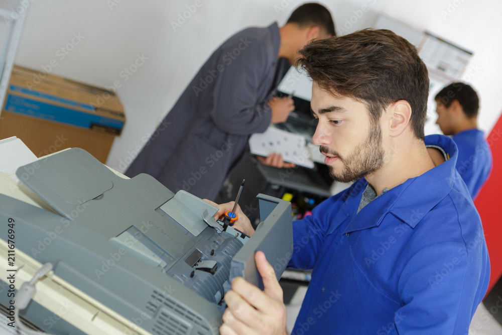 young repairer fixing photocopier young repairer fixing photocopier