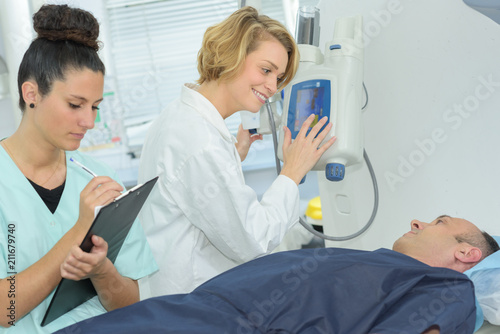 nurse taking notes when doctor talking to patient in ward