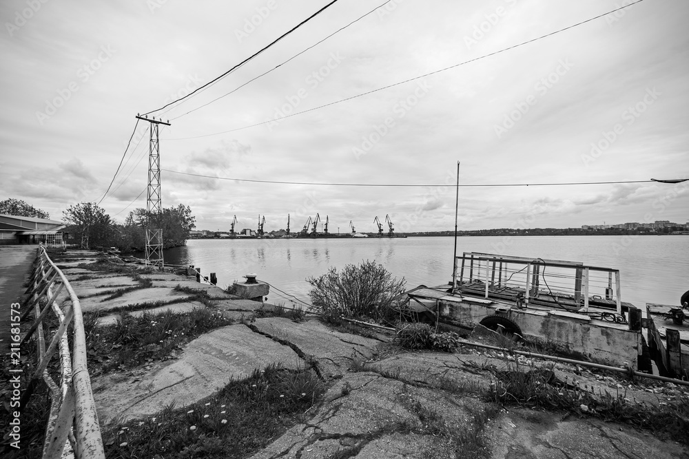 Black and white landscape with the old pier and port cranes in the distance