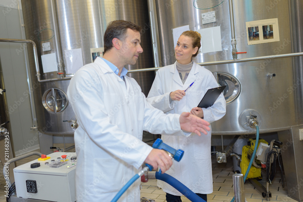 cheerful man and woman wearing uniform factory workers