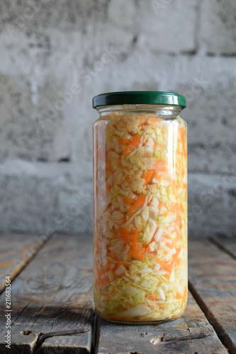 Sauerkraut in glass jar, marinated cabbage and carrot. Probiotic and fermented food. Pickles. Canned vegetarian food concept.