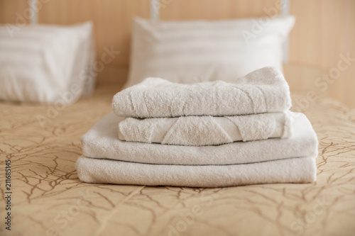 Fototapeta Naklejka Na Ścianę i Meble -  Stack of white hotel towel on bed in hotel. Soft focus.