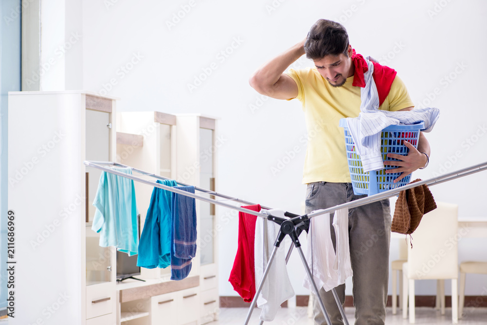 Handsome man husband doing laundering at home Handsome man husband doing laundering at home