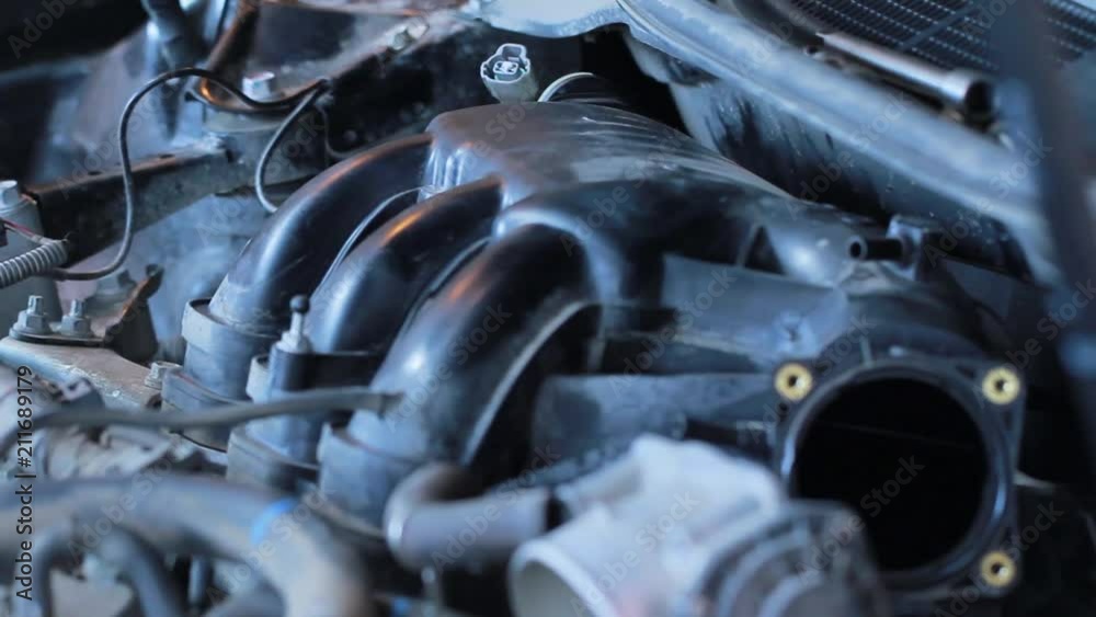 The mechanic installs the cover of the internal combustion engine. Car repair station The mechanic installs the cover of the internal combustion engine. Car repair station