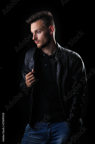 man on a black background / young man on a black background in a leather jacket