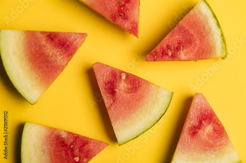 Fresh sliced watermelon on a bright yellow background