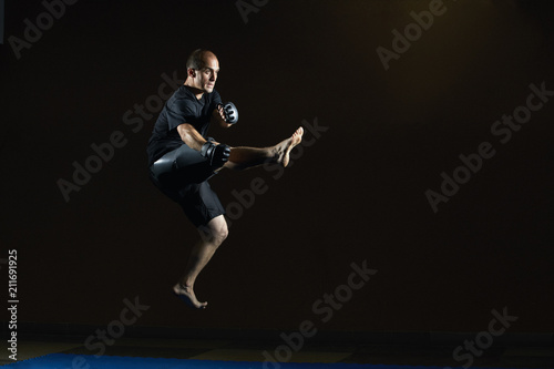 In black clothes, a man beats a kick in a jump © andreyfire