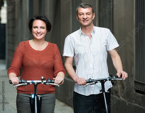 couple with electrkc bikes in vacation on city street photo