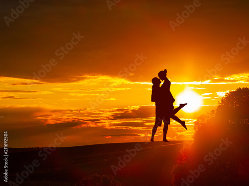 Romantic couple on countryside at the sunset with the sun and one tree © anuskiserrano
