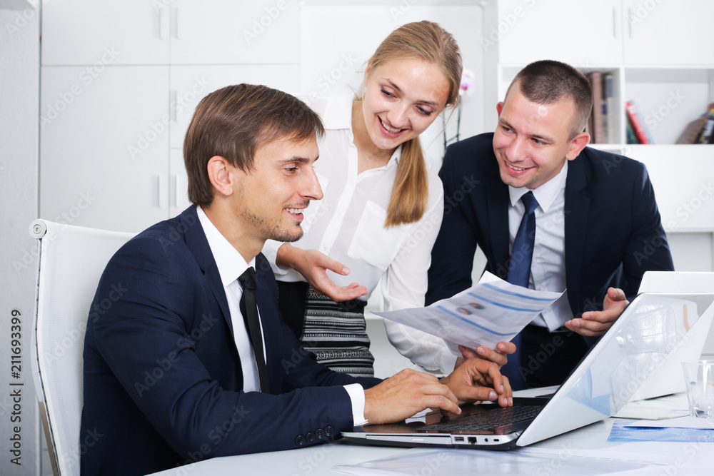 Fototapeta premium Three glad business workers holding documents