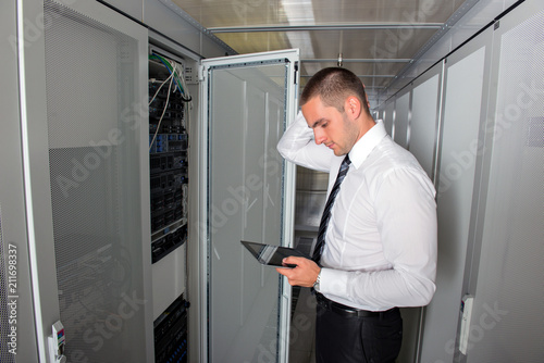Young handsome business man engeneer in datacenter server room © blicsejo