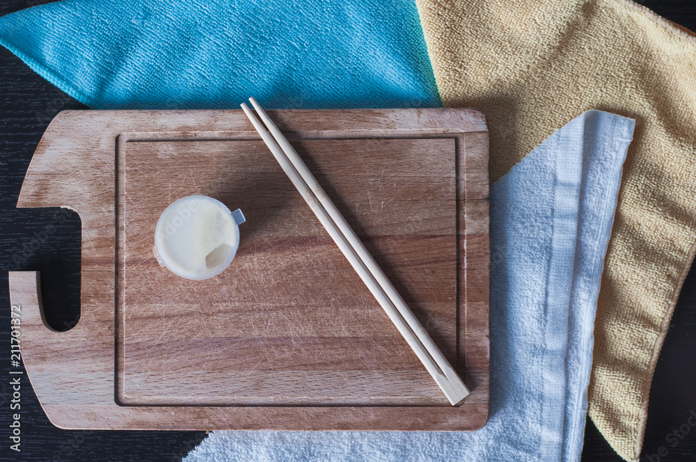 Fototapeta premium Chinese chopsticks with white sauce on the wooden board. Top view on the bamboo sticks