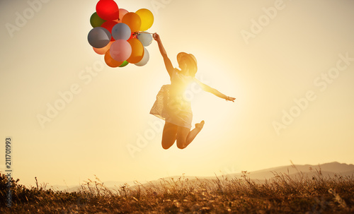 happy woman with balloons at sunset in summer